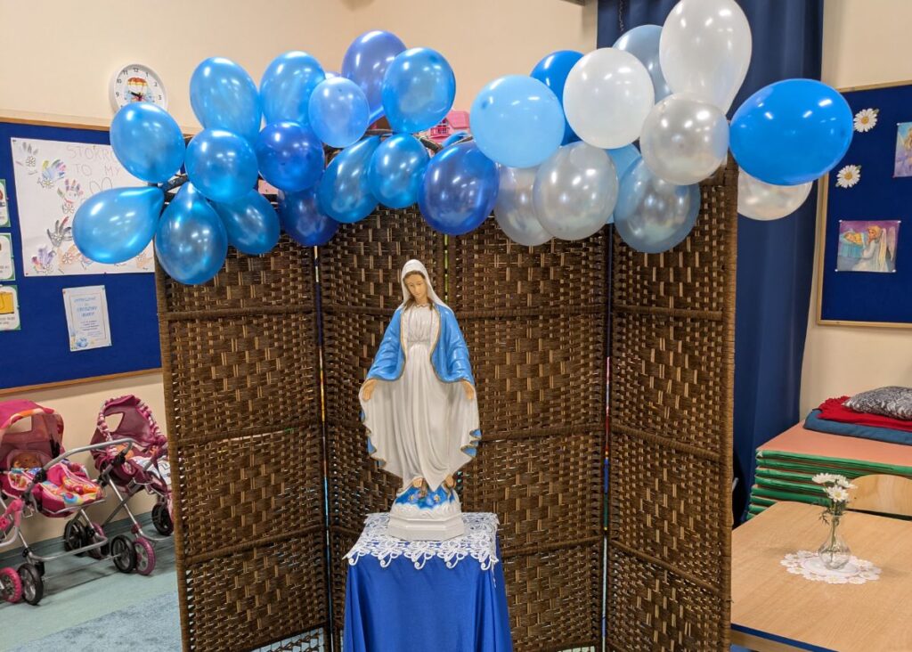 Figurka Maryi, nad nią balony