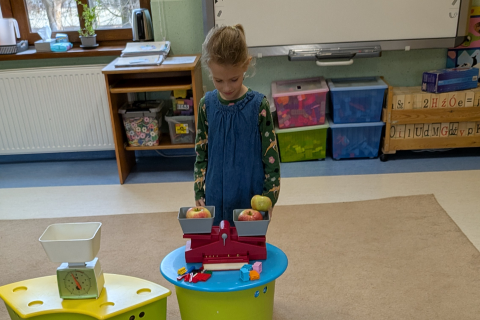 dziewczynka warzy na wadze owoce