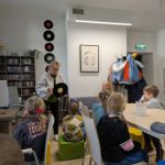 Stokrotki w Bibliotece - pani pokazuje dzieciom płytę winylową