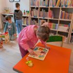 Stokrotki w Bibliotece - dzieci bawią się zabawkami, dziewczynka układa układankę