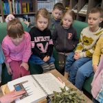Stokrotki w Bibliotece - dzieci oglądają książkę w języku braille'a