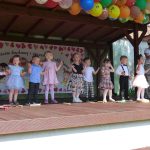 Dzieci na scenie pokazują i mówią wierszyk