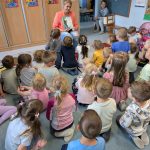 Mama pokazuje okładkę książki dzieciom