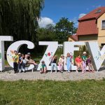 Dzieci siedzące na literach tworzących napis Tczew