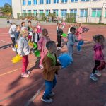 Dzieci tańczące z pomponami na boisku szkolnym