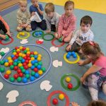 dzieci liczą piłki w obręczach