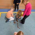 dzieci liczą kasztany na dywanie