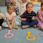 dzieci siedzą na dywanie z kolorowymi kluczami