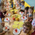 dzieci siedzą przy uroczystym posiłku