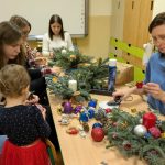 Rodzice z dziećmi tworzą stroiki świąteczne