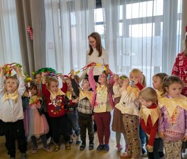 Grupa prezentuje wspólnie wykonany papierowy łańcuch na choinkę