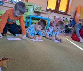 chłopcy rysują dinozaura według wzoru