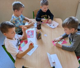 chłopcy wykonują pracę plastyczną Park jurajski